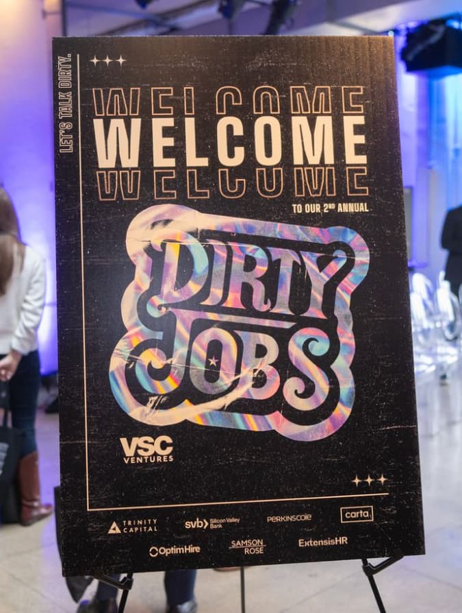 A speaker presenting on stage at Dirty Jobs Summit